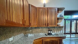 Una cocina con armarios de madera, encimeras de granito y una isla integrada.