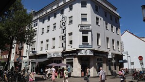 A corner building with multiple signs including "HOTEL HORSTMANN" and "NICE LADY" indicating a hotel and possibly a restaurant or bar. - Hotel Horstmann (Münster)