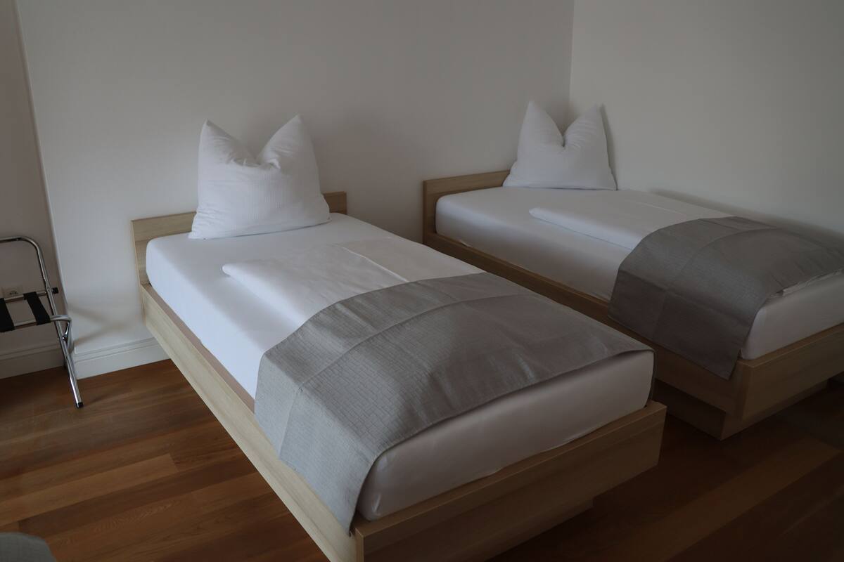 Two single beds with wooden frames and white bedding.
