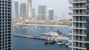 A marina with yachts docked, a city skyline in the background, and high-rise buildings. - KeyRock - Palm View Apt with Pool (Dubai)