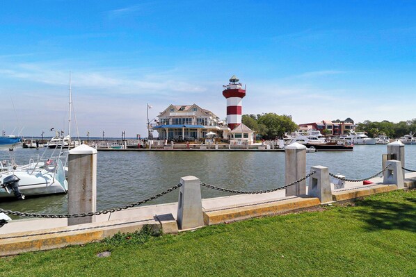 A waterfront property with a lighthouse, marina, and a building with multiple decks and outdoor seating. - The Jewel of Harbour Town in world renown Sea Pines (Hilton Head Island)