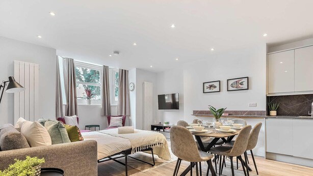 Un appartement moderne comprenant un coin repas, un canapé, une télévision et une cuisine.