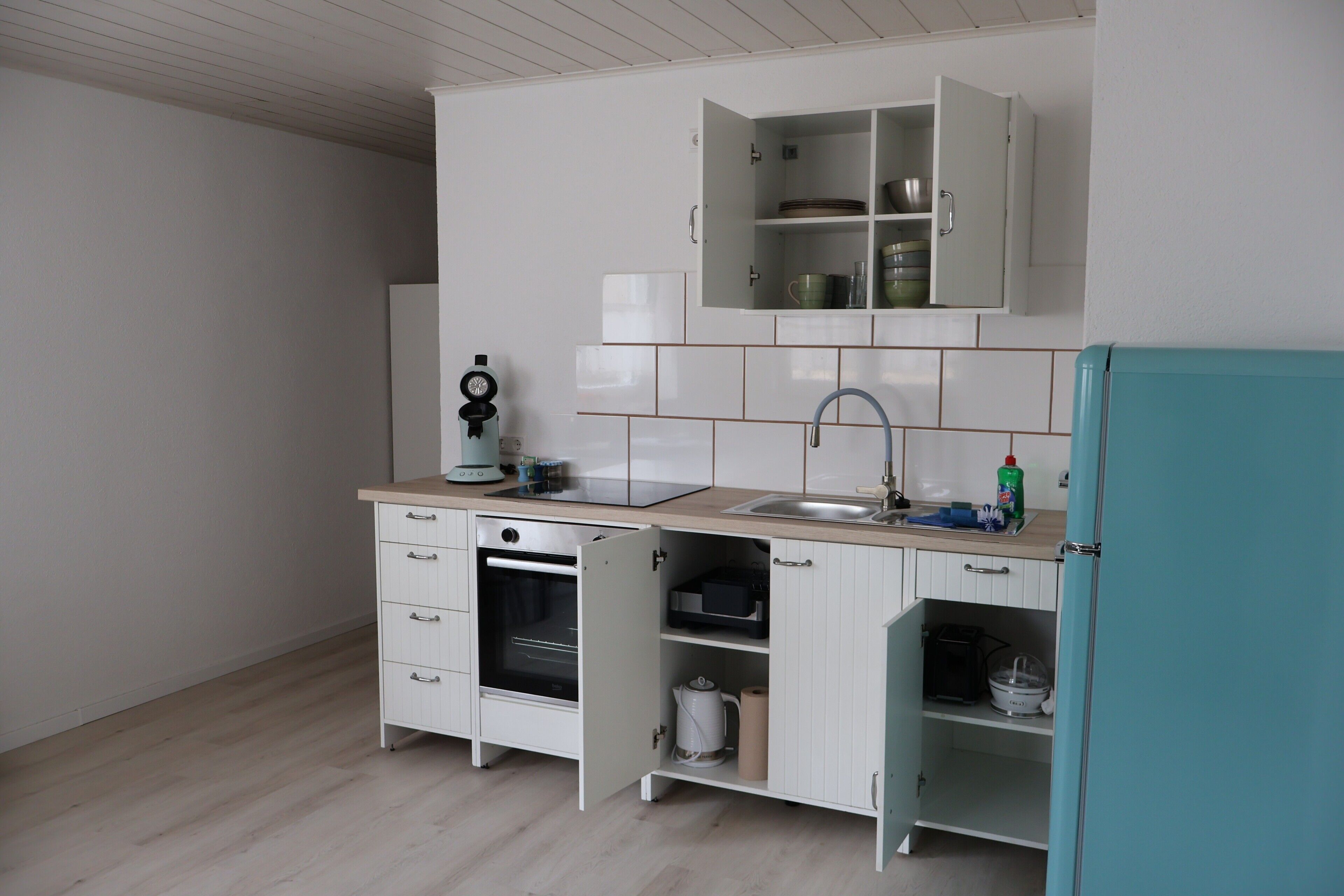 Een koelkast, een oven, een kookplaat, een koffiezetapparaat/waterkoker