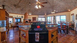 A kitchen with a brick ceiling, a stove, and a ceiling fan. - Campo Bello – Rooftop Terrace, Las Conchas (Puerto Peñasco)