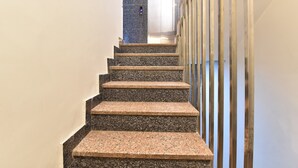 Een trap met granieten treden die naar een lift leiden.