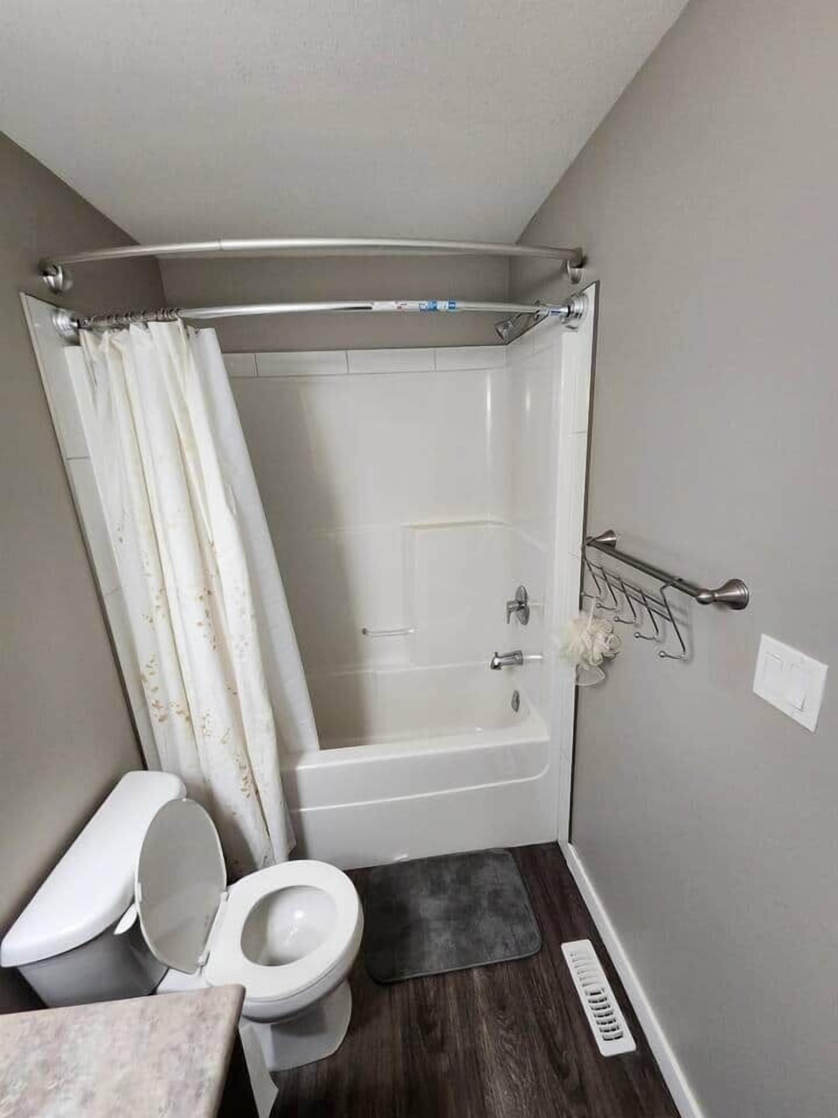A small bathroom with a shower, toilet, and sink.