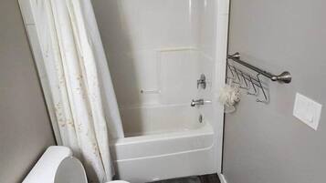 A small bathroom with a shower, toilet, and sink.