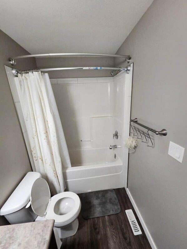 A small bathroom with a shower, toilet, and sink.