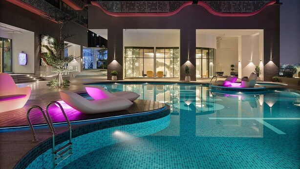 Ein moderner Poolbereich im Innenbereich mit Liegestühlen und Blick ins Innere des Gebäudes.