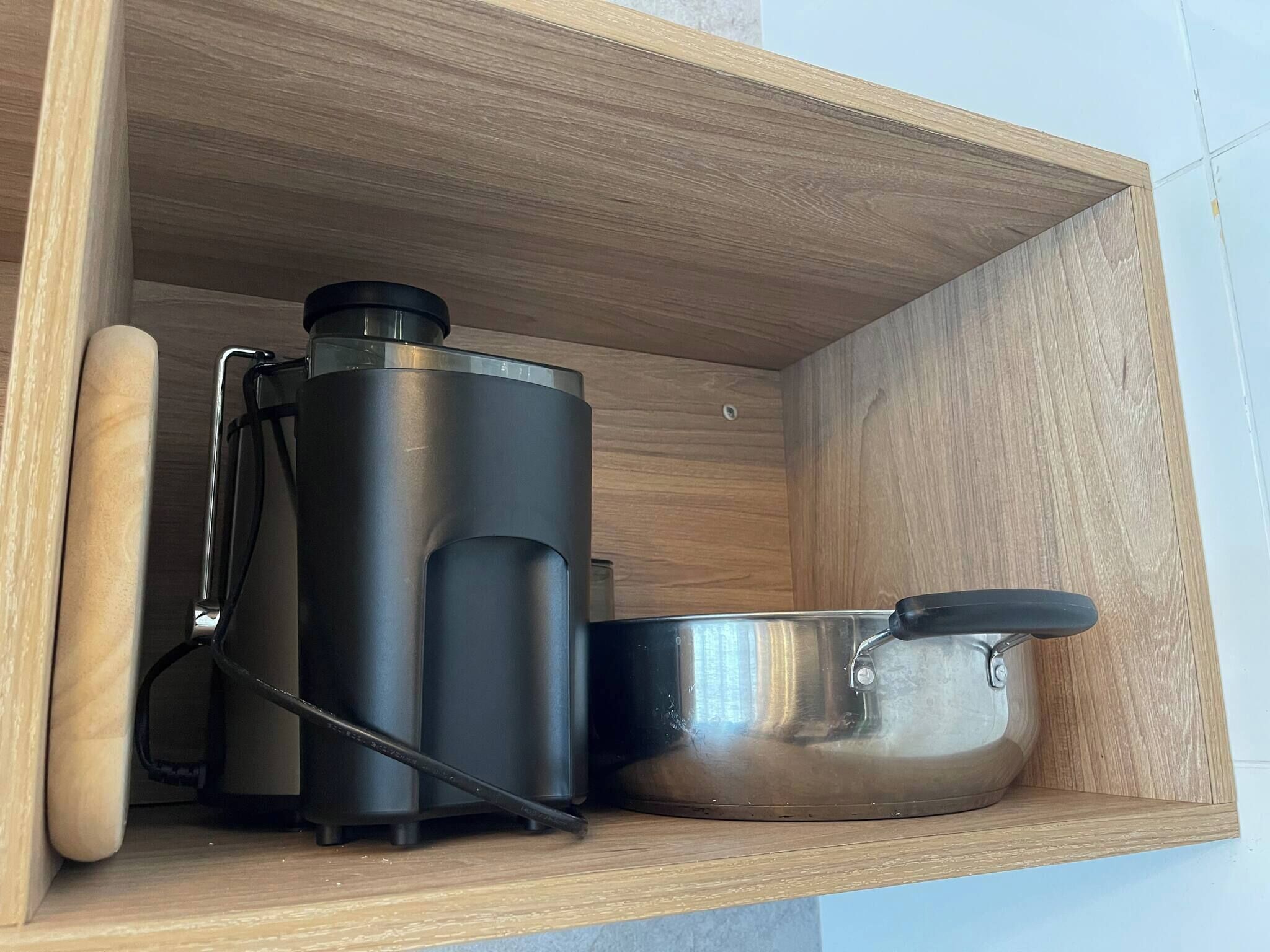 A wooden shelf with a stainless steel thermos, a kettle, and a pot.