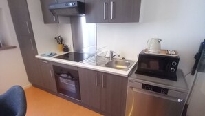 A compact kitchen with a microwave, dishwasher, and a small sink.