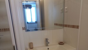 A bathroom with a white sink, mirror, and two drawers.