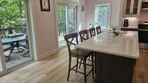 Una cocina moderna con una isla grande, suelo de madera y ventanas amplias que ofrecen vistas al exterior.
