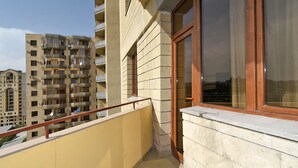A balcony with a view of adjacent high-rise buildings.