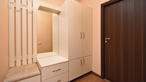A bedroom with a wardrobe, a mirror, and a door.