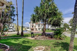 A residential area with a large house, palm trees, and a well-maintained lawn. - Boho Beach Bliss 2BR Retreat Steps From the Sand (Indian Rocks Beach)