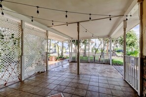 A covered outdoor area with tiled flooring, string lights, and white lattice panels. - Boho Beach Bliss 2BR Retreat Steps From the Sand (Indian Rocks Beach)