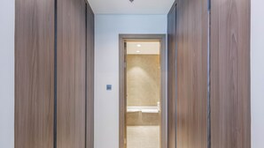 A hallway with wooden doors leading to a bathroom.