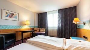 A hotel room with a bed, a desk, a chair, a lamp, and a window with curtains. - enjoyHotel garni Korntal Stuttgart  (Korntal-Munchigan)