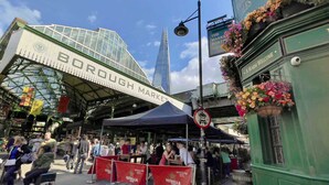 Borough Market with a glass structure, outdoor seating, and a prominent building in the background. - Chic and cosy apartment near Borough Market (Greater London)