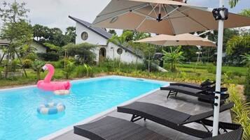 A swimming pool with lounge chairs and umbrellas.