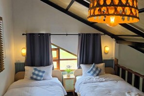 A bedroom with two beds, a ceiling fan, and a view of the outdoors. - AUN-I-NA Home stay at Nakhon Phanom (Nakhon Phanom)
