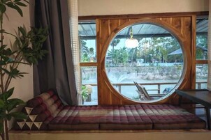 A circular window with a view of a bridge and greenery.