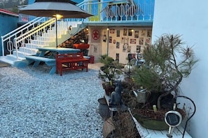 A patio area with a staircase, outdoor seating, and potted plants. - JIN bok rotj (Uljin-gun)