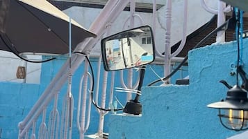 A vehicle's side mirror with a reflection of a building and a street.