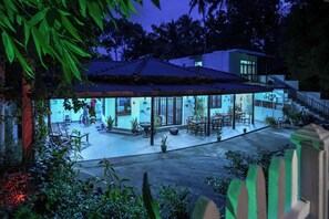 Una casa moderna con patio coperto, posti a sedere all'aperto e una scala che conduce a un piano superiore.