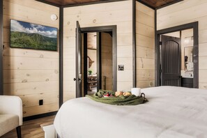 Une chambre confortable avec un lit, un téléviseur fixé au mur et une porte donnant sur une salle de bain.