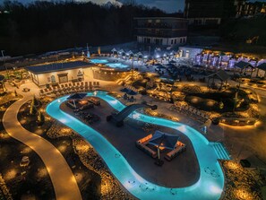Ein Resort mit großem Schwimmbecken, Liegebereichen und einem mehrstöckigen Gebäude.