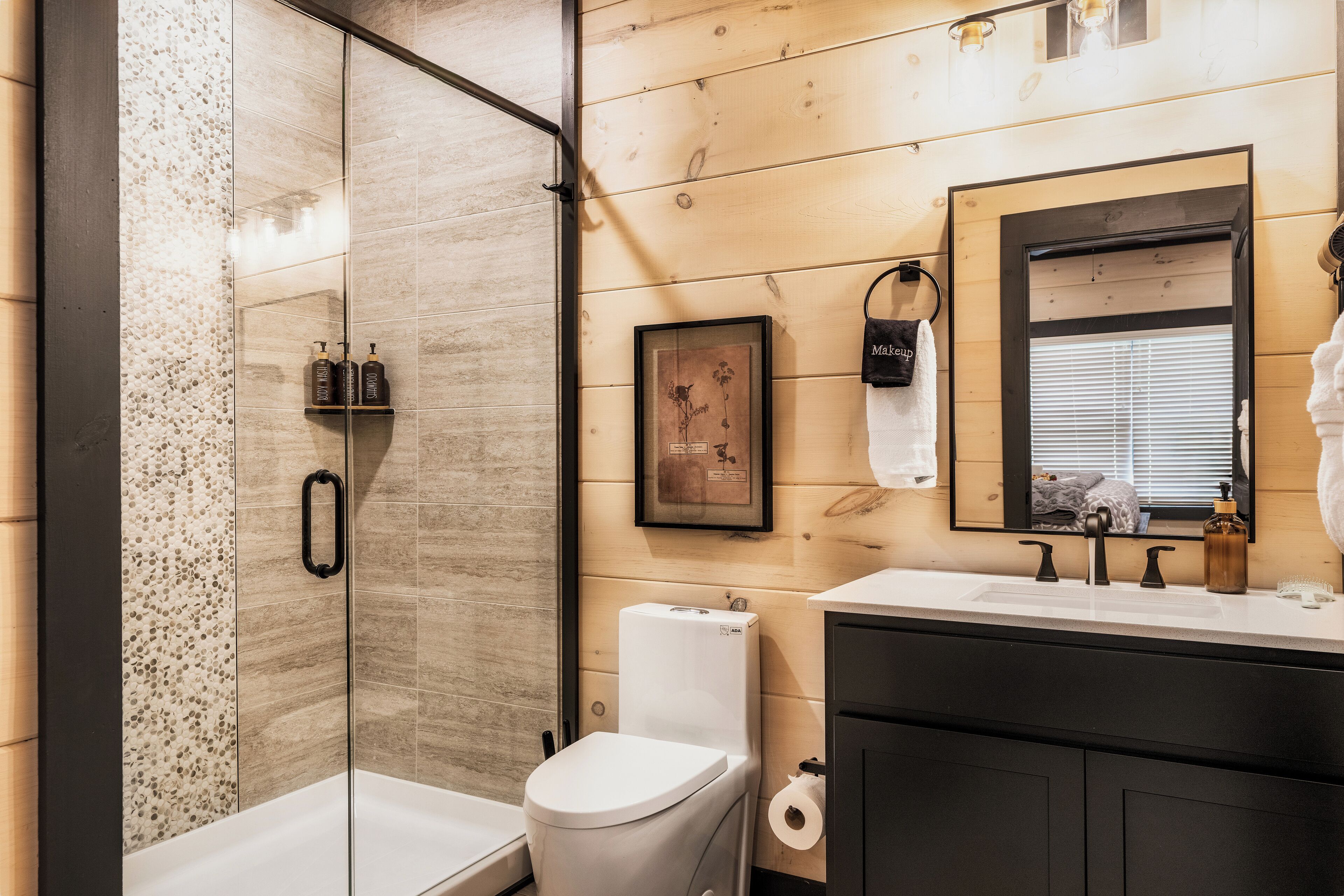 Een moderne badkamer met douche, toilet, wastafel en badkamermeubel.