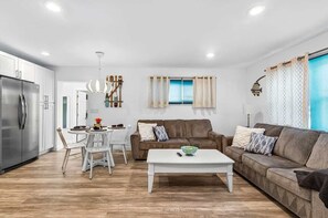 A modern living space with a kitchen, dining area, and seating area.