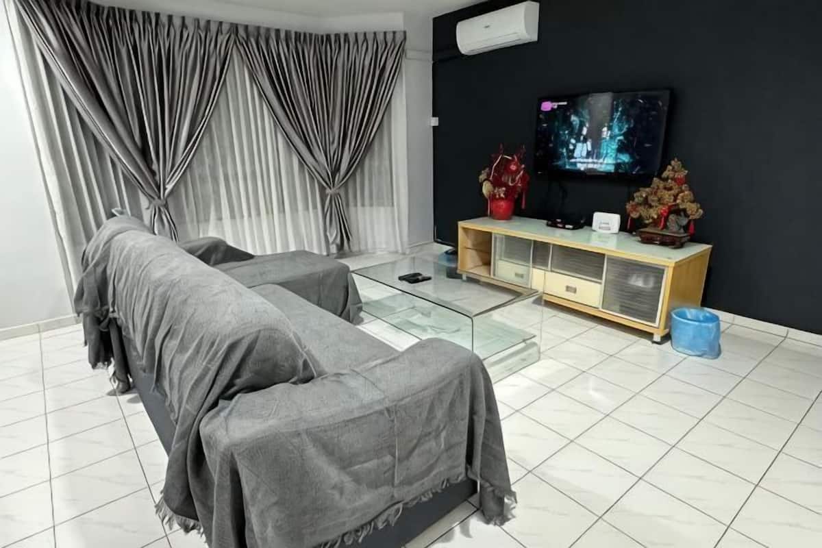 A modern living room with a sofa, a TV, a console table, and a large window with curtains.
