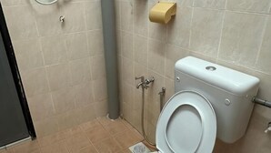 Ein Badezimmer mit Toilette, Bidet und Papierhandtuchspender.