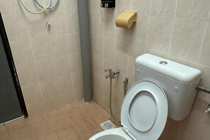 A bathroom with a toilet, bidet, and paper towel dispenser. - JL Homestay Bahau (Bahau)