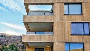 A multi-story building with wooden paneling, balconies, and large windows. - Residence Du Parc - Awa Apt 16a (Arthurs Point)