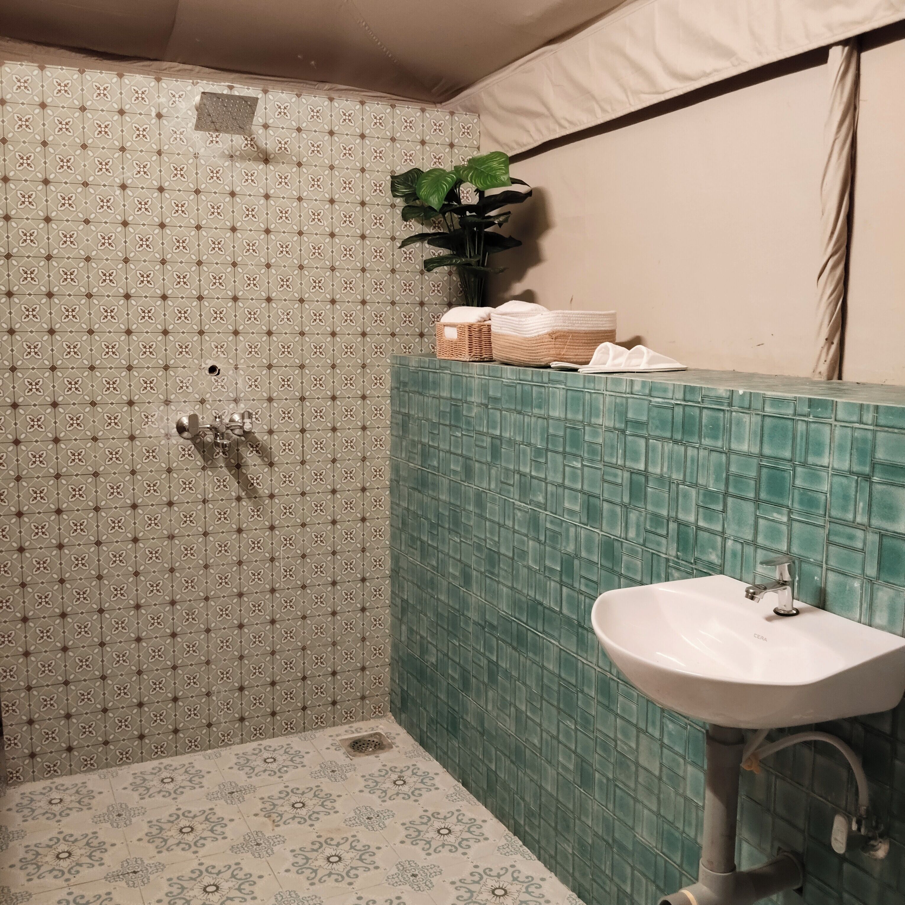 A bathroom with patterned tiles, a sink, and a shower.