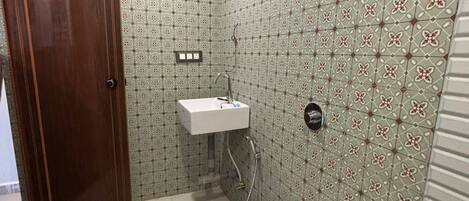 A small bathroom with a toilet, sink, and patterned walls.