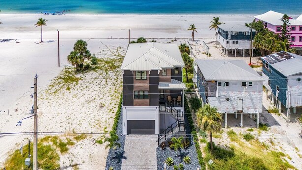 A beachfront property with a modern house, a beach, and a clear view of the ocean. - 5350 Chasing Sunshine: 5bd/4.5ba Pool Home! 5 Bedroom Home (Fort Myers Beach)