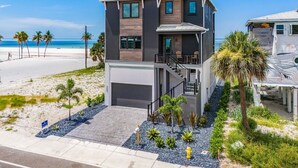 A modern two-story house with a balcony, located near a beach. - 5350 Chasing Sunshine: 5bd/4.5ba Pool Home! 5 Bedroom Home (Fort Myers Beach)