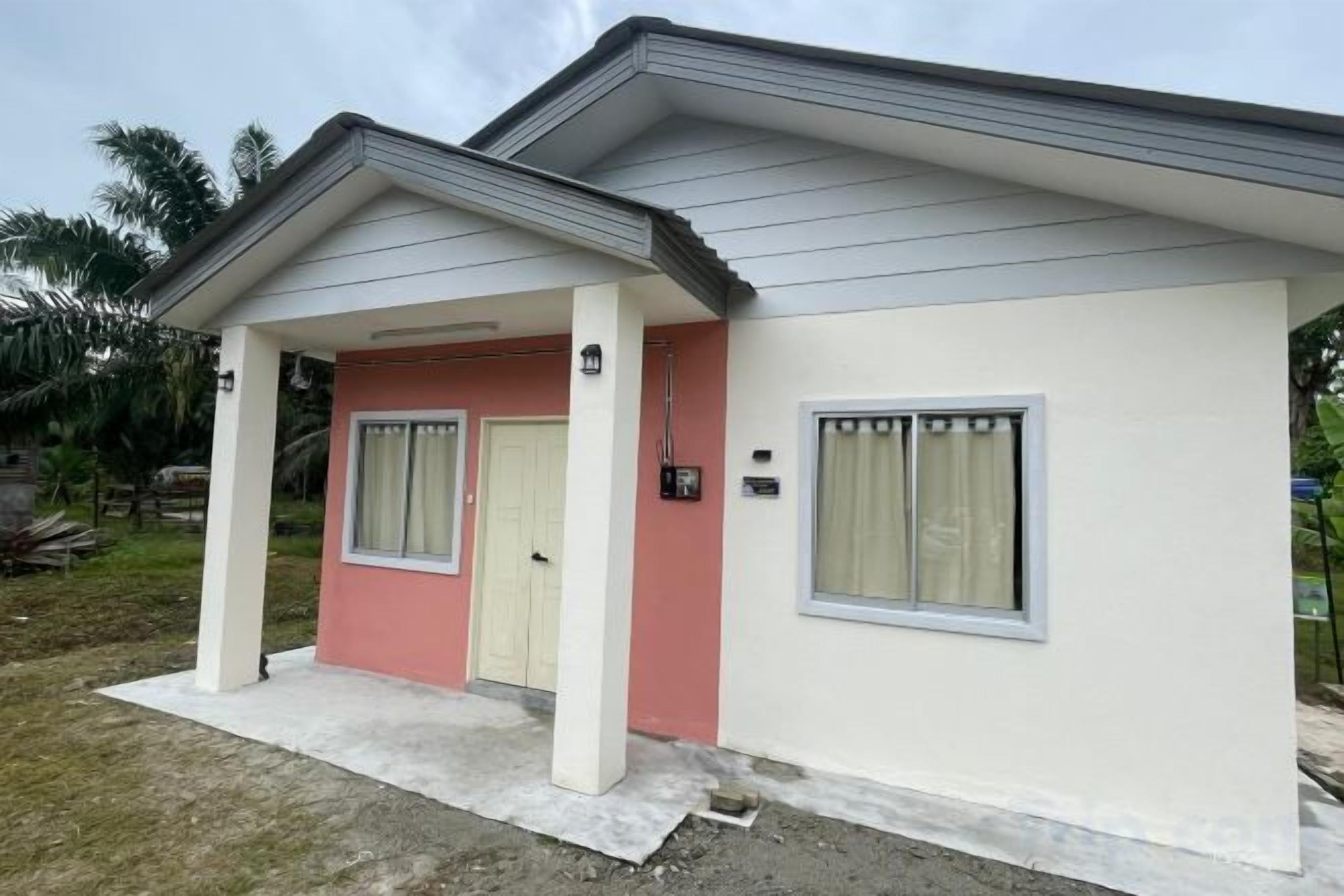 Uma casa térrea com varanda, uma porta e duas janelas.