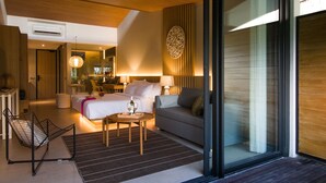 Moderni hotellihuone, jossa on sänky, sohva ja ruokailutila.