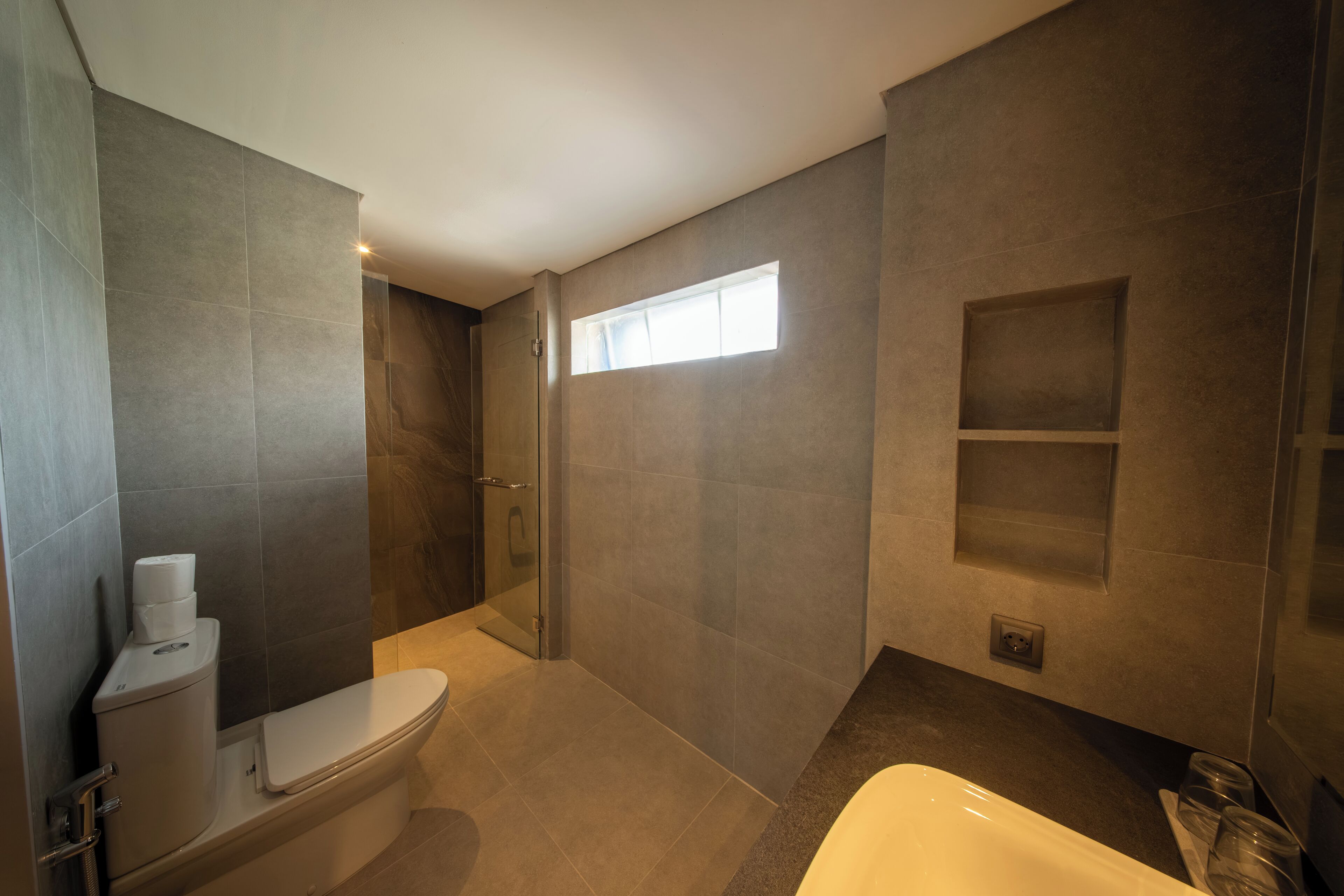 Une salle de bain moderne équipée de toilettes, d’une douche et d’une baignoire.