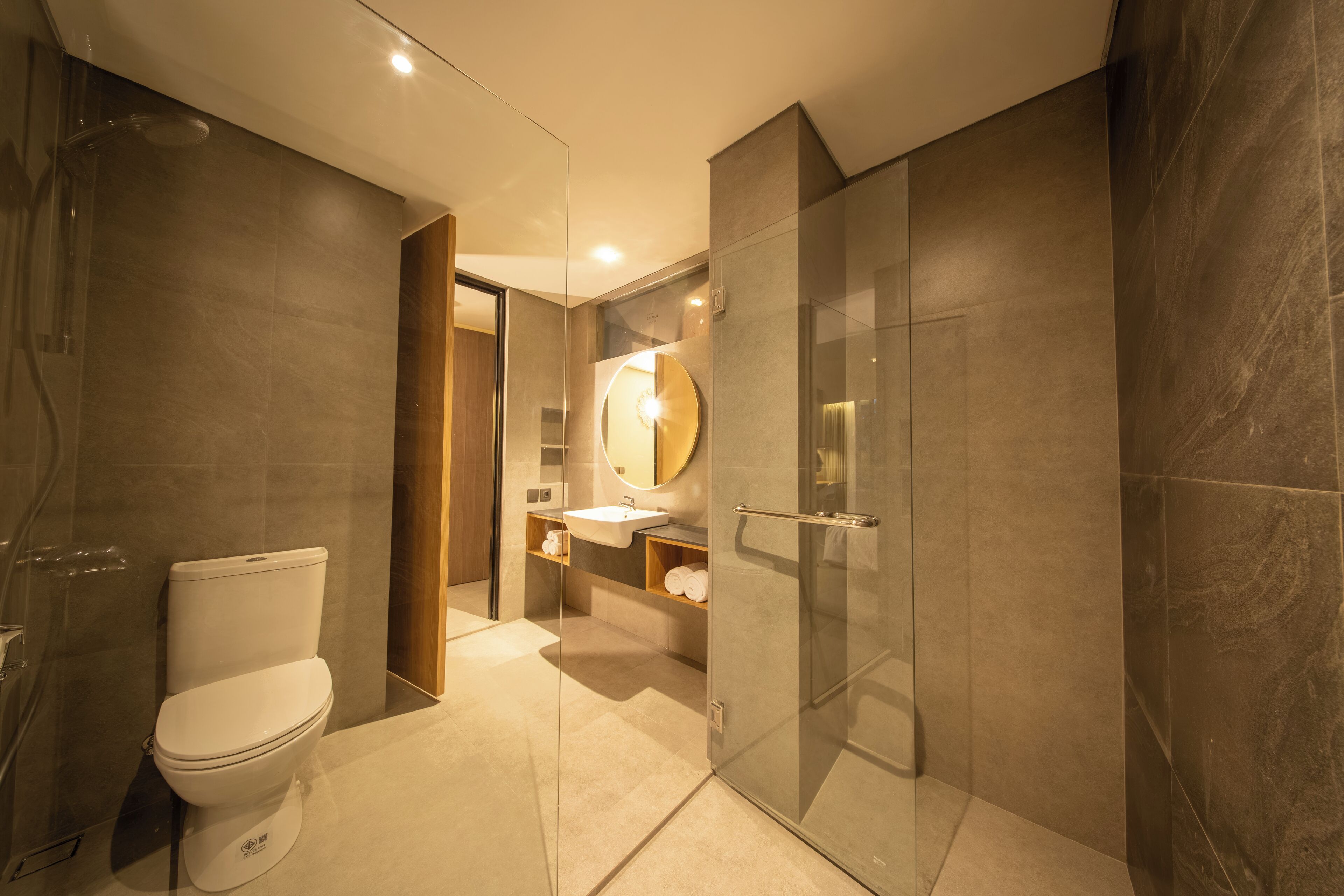 Een moderne badkamer met toilet, wastafel en douchecabine van glas.
