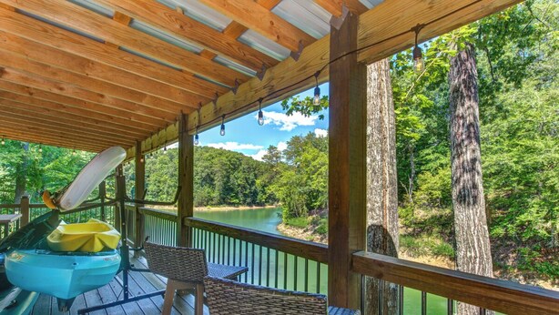 Une terrasse en bois offrant une vue sur une rivière et une forêt.