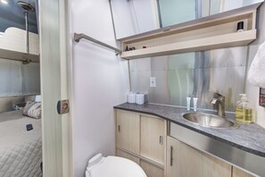 Une petite salle de bain comprenant un lavabo, un miroir et des toilettes.