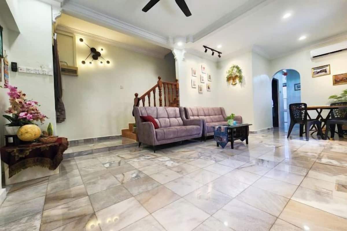 A spacious living area with a sofa, a coffee table, and a staircase leading to another room.