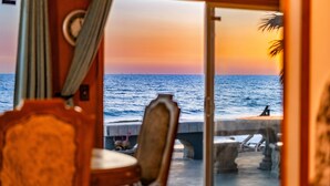 A room with a view of the sea at sunset, a wooden chair, and a table with a view. - 25% Off Aug WkDays On The Sand, Perfect 4 Families (Ventura)